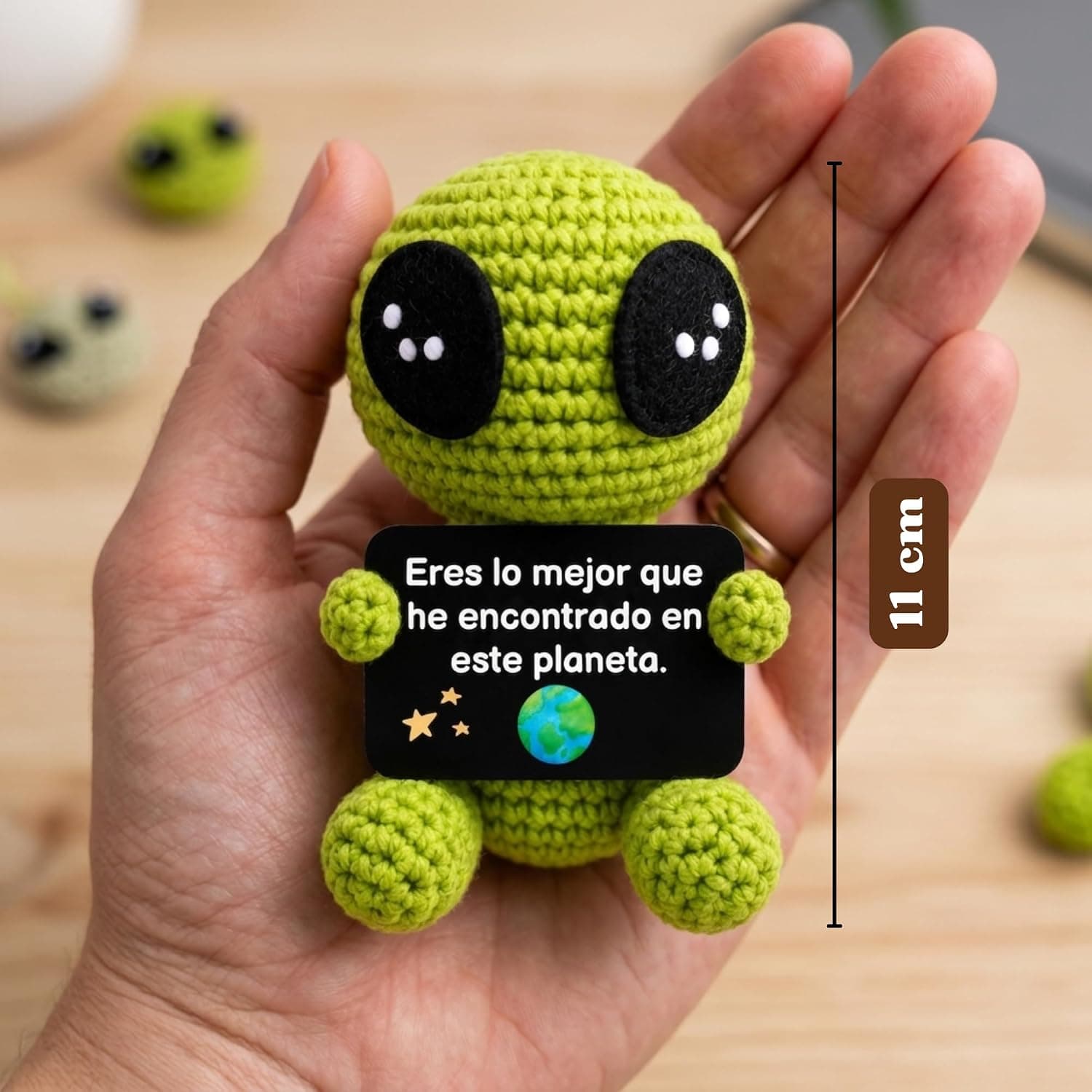 El alien de ganchillo visto de perfil, mostrando el tamaño junto a una mano