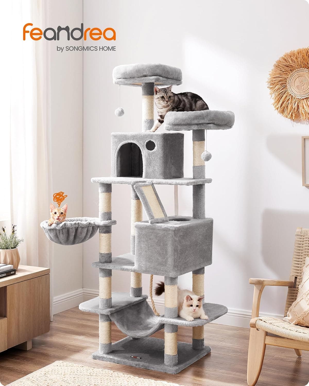 El árbol montado en el salón de una casa, con dos gatos repartidos entre la caseta y la plataforma superior