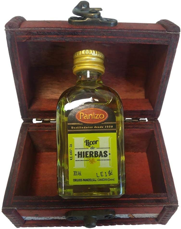 Baúl de madera en miniatura abierto, con estampado de mapa antiguo y cierre metálico, con una botellita de licor de hierbas Panizo en su interior