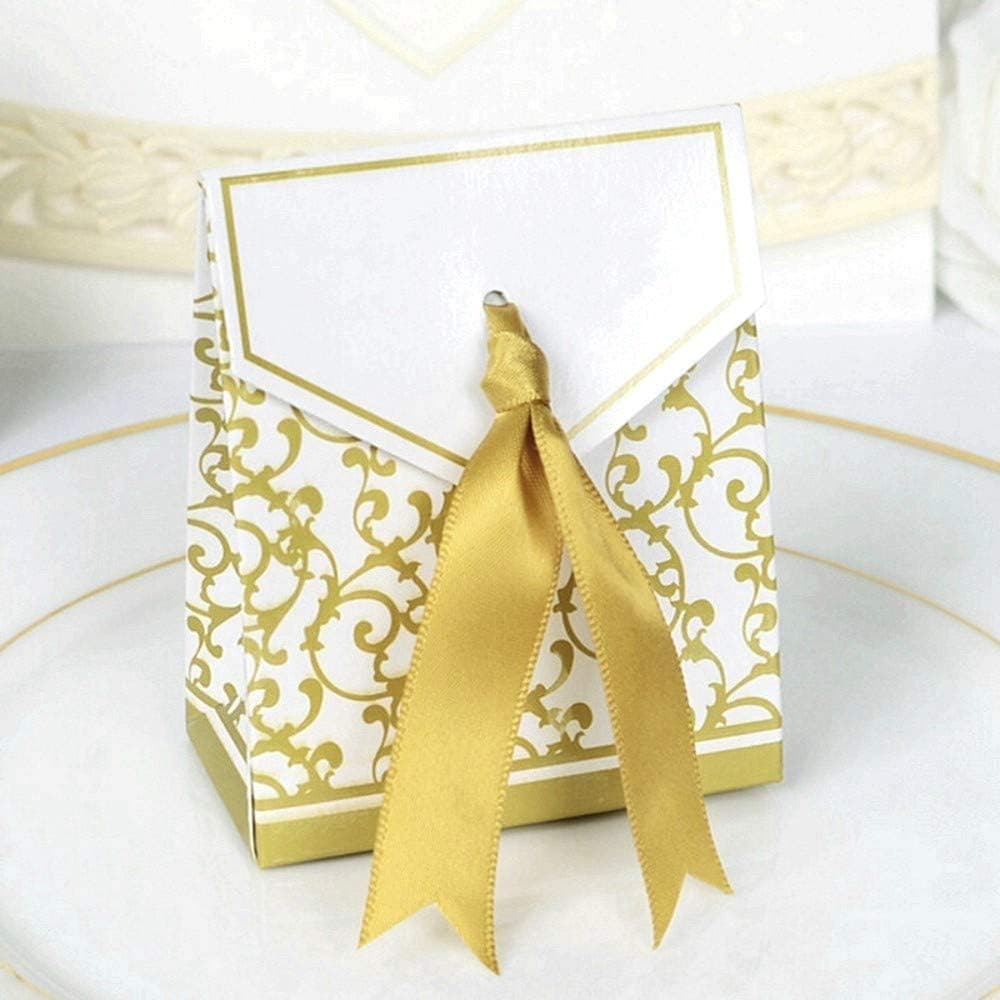 Una cajita vista de cerca sobre un plato, con la solapa frontal en blanco y el lazo dorado