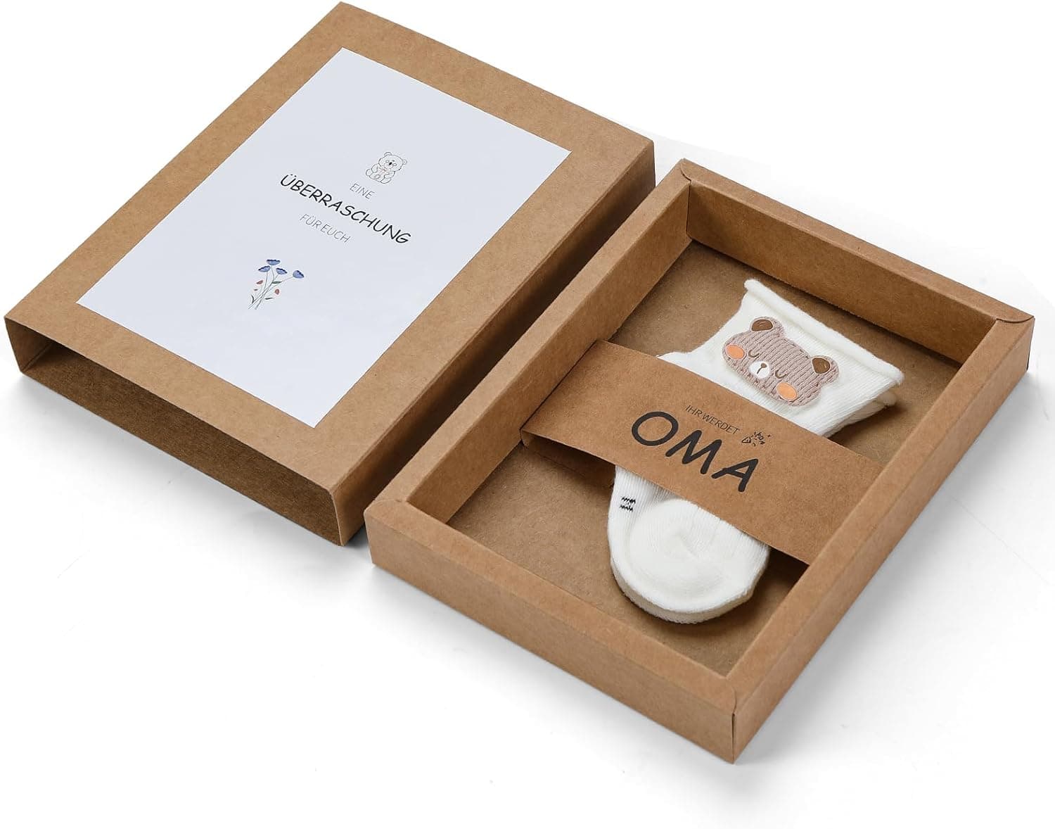 Caja de regalo con calcetines blancos de bebé con un osito bordado, para anunciar un embarazo a los abuelos