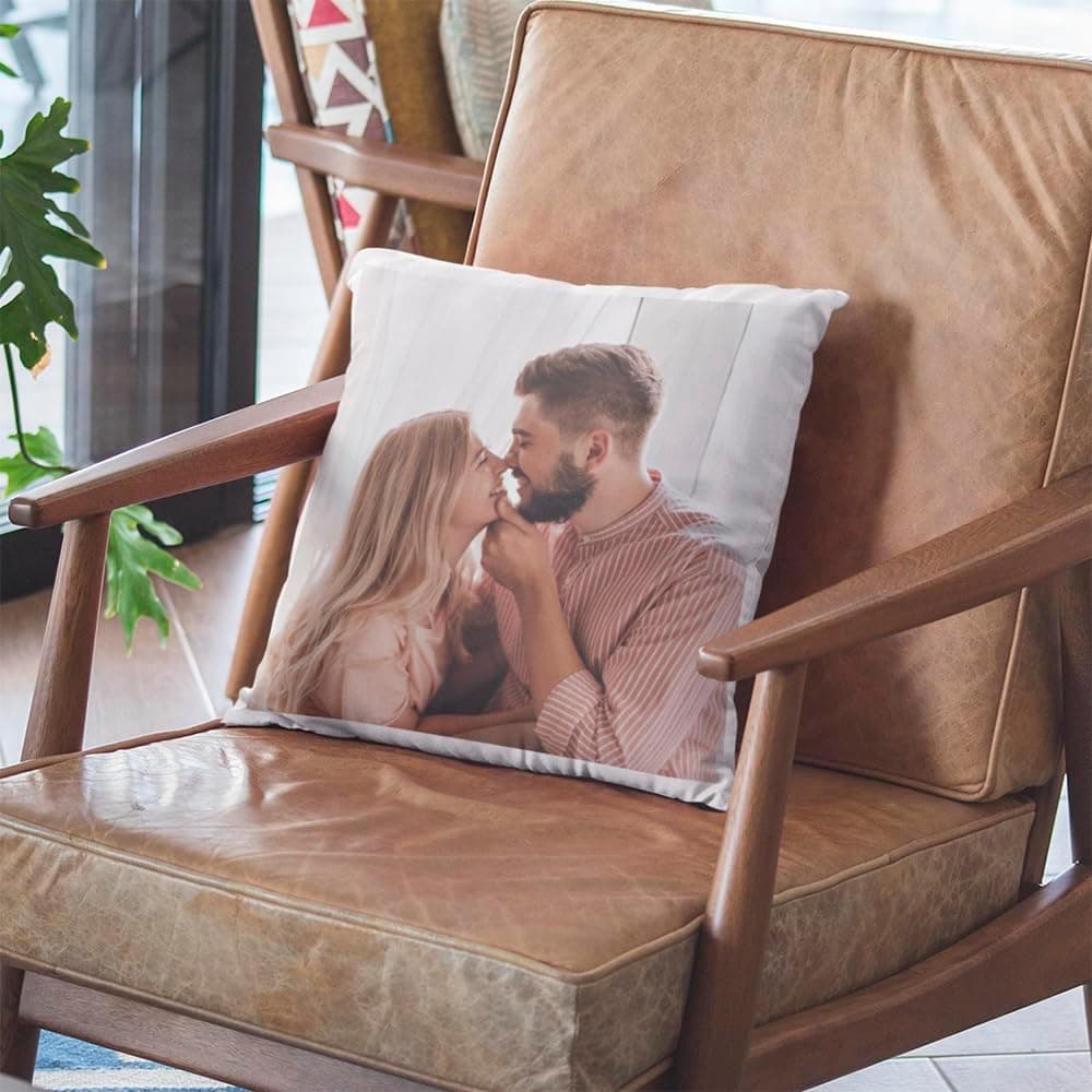 El mismo cojín en un sillón gris junto a una planta, con la foto ocupando toda la cara