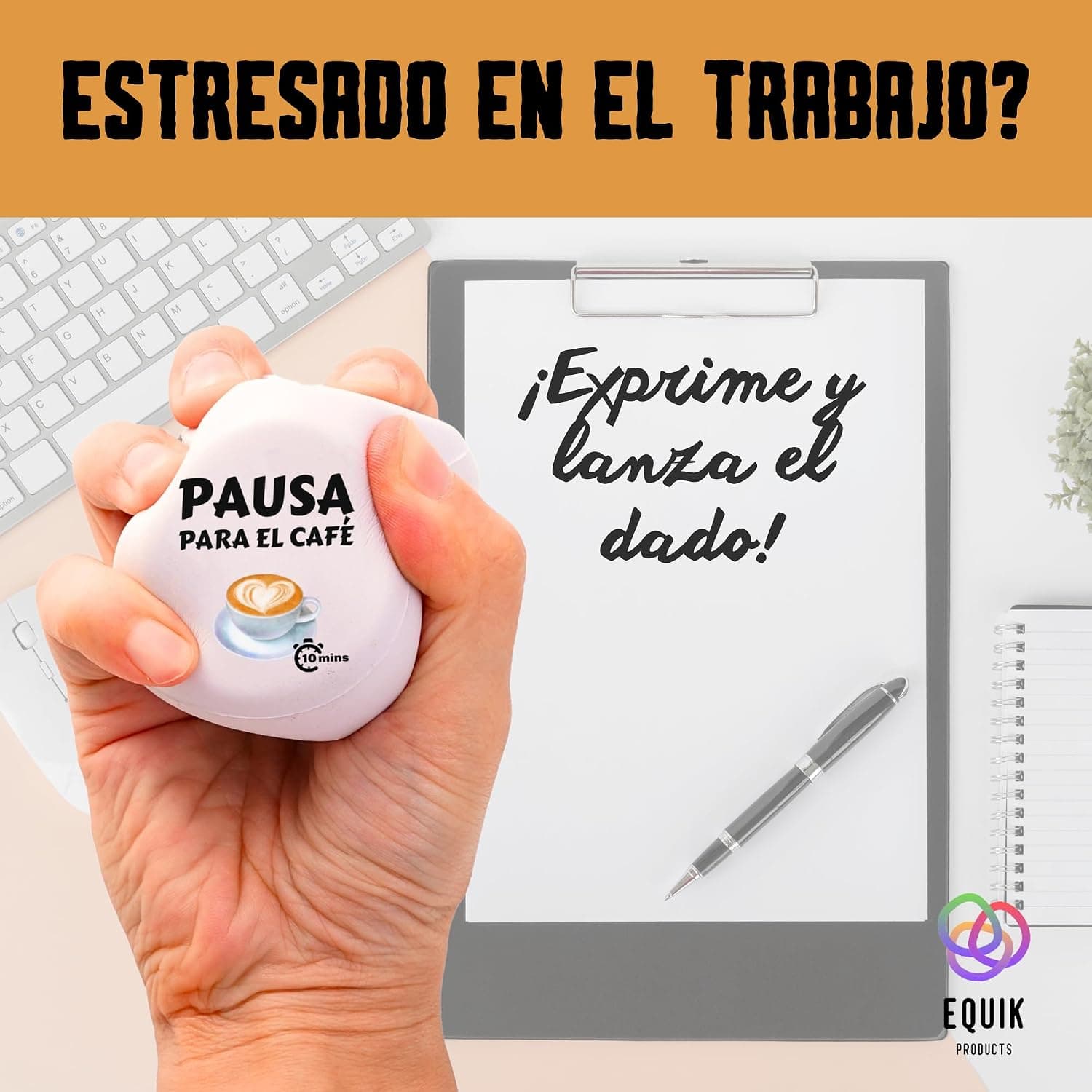 El dado apretado en una mano junto a un teclado y una libreta sobre la mesa