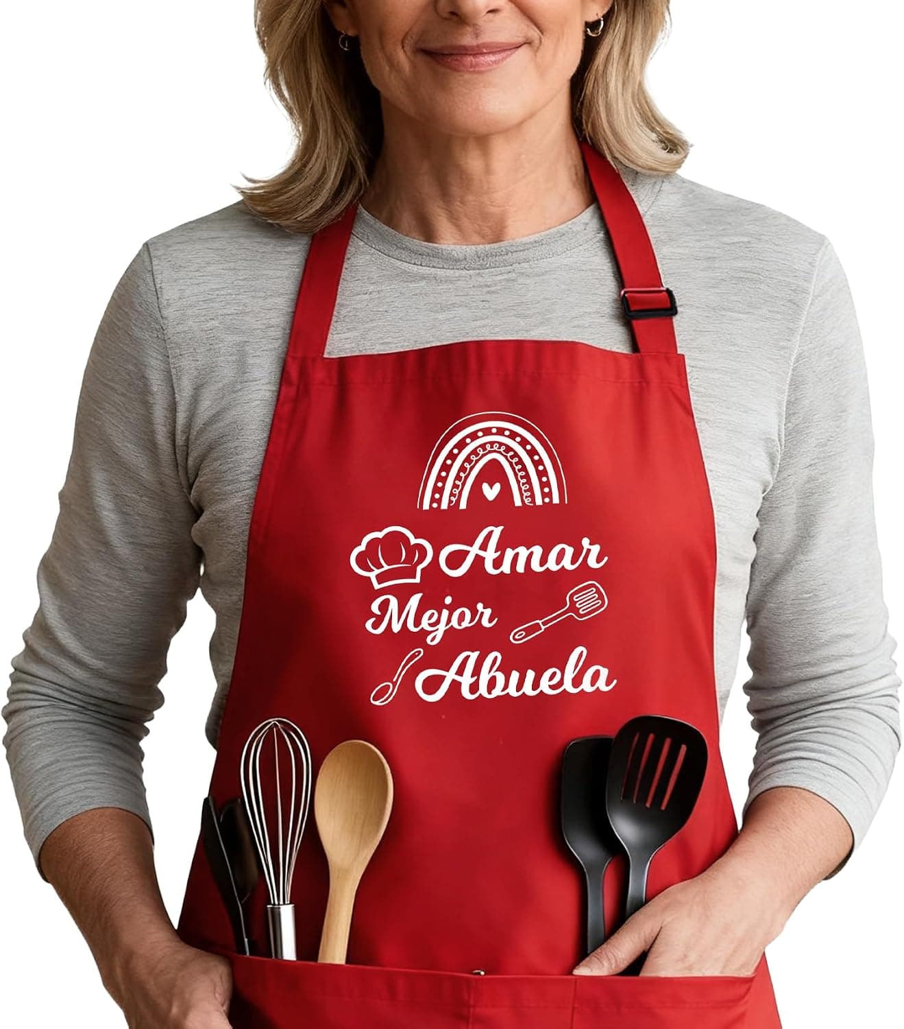 Una mujer con el delantal rojo puesto, con la frase «Amar mejor abuela» y utensilios de cocina asomando por el bolsillo