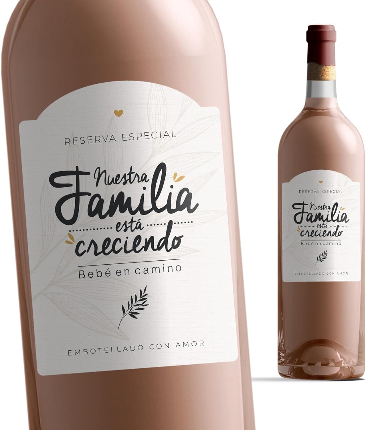 Manos sujetando una botella con una etiqueta que dice «nuestra familia está creciendo, bebé en camino»
