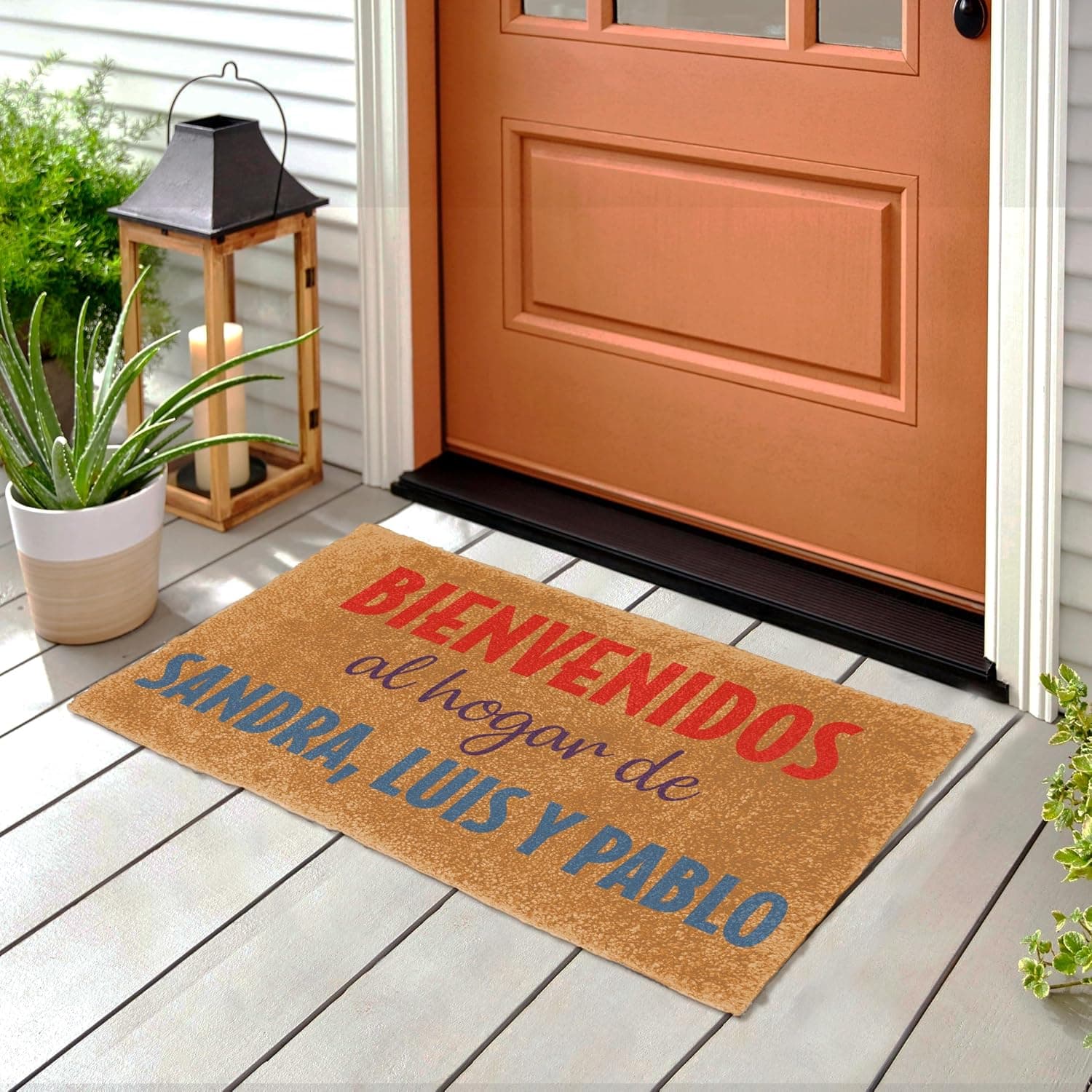 El felpudo colocado en la entrada de una casa con puerta naranja