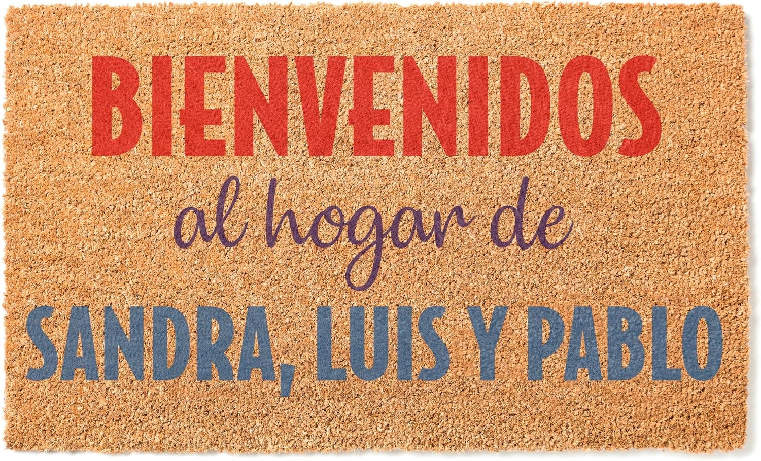 Felpudo de coco con «Bienvenidos al hogar de Sandra, Luis y Pablo» en rojo, morado y azul