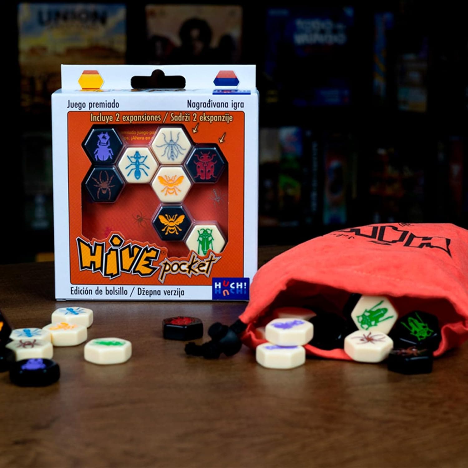 Bolsa de tela de Hive Pocket con las fichas hexagonales repartidas sobre una mesa oscura