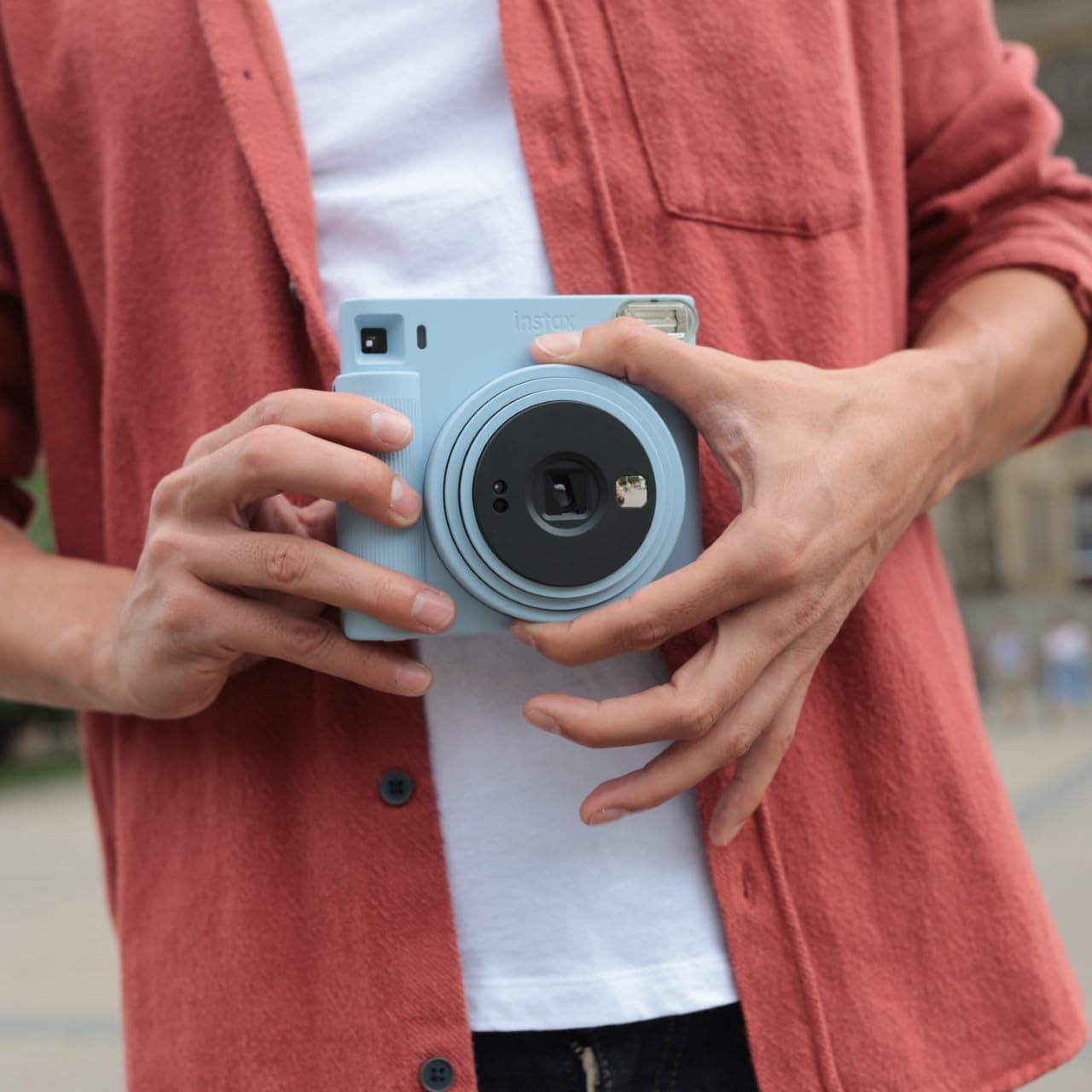 Detalle del objetivo giratorio de la Instax SQ1 para encenderla