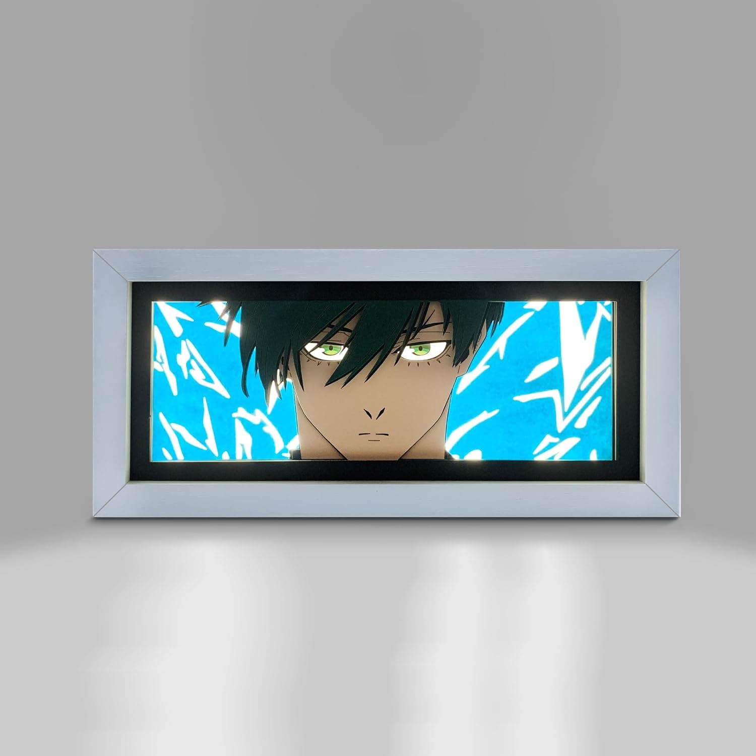 La caja de luz encendida en la pared, con la cara de Rin Itoshi recortada sobre fondo azul