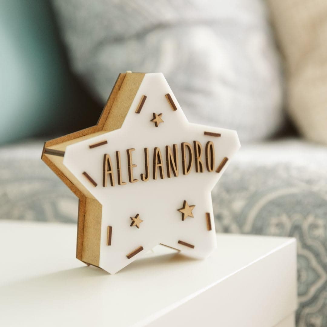 Unas manos colocando las letras de madera del kit sobre la estrella para formar un nombre