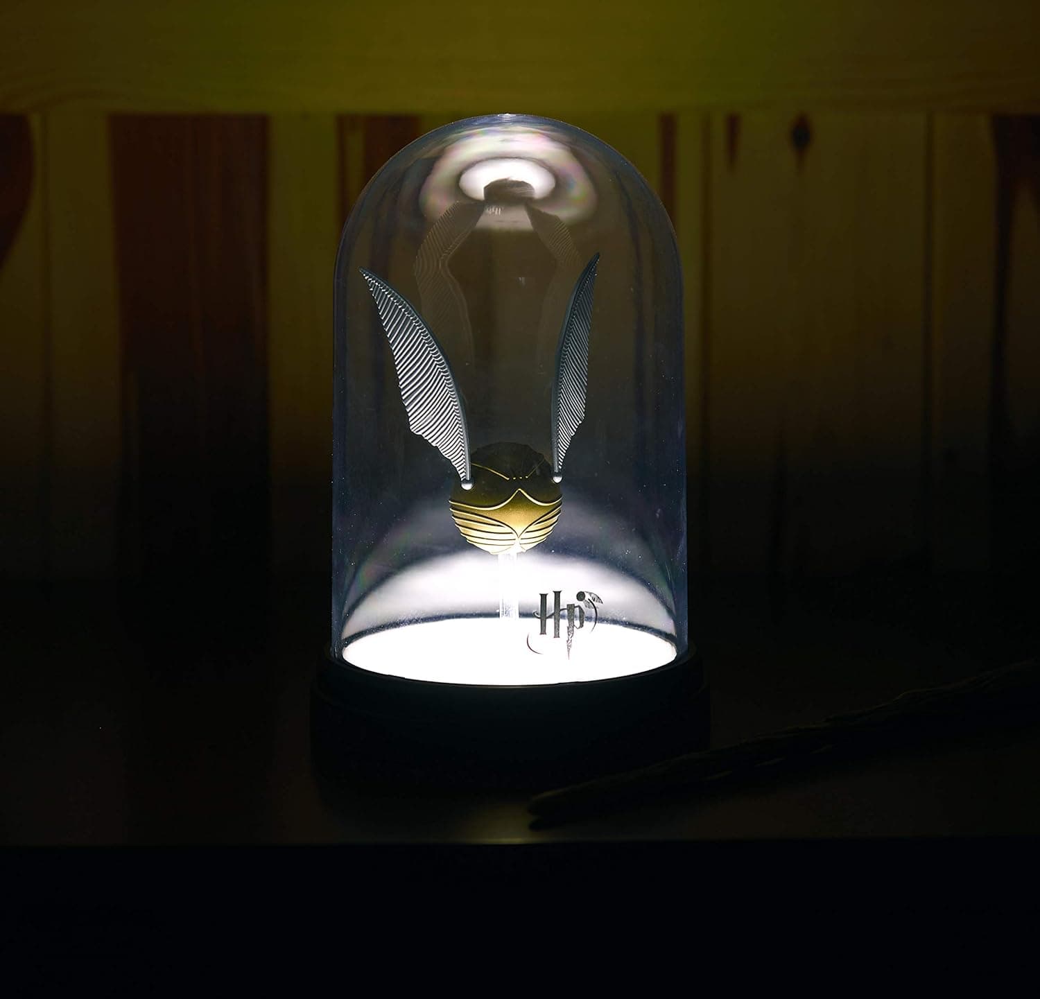 La lámpara encendida en una habitación a oscuras, con la snitch iluminada desde abajo