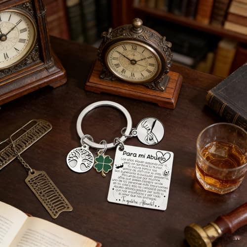 El llavero apoyado sobre una mesa oscura junto a un reloj antiguo, un vaso y unos libros