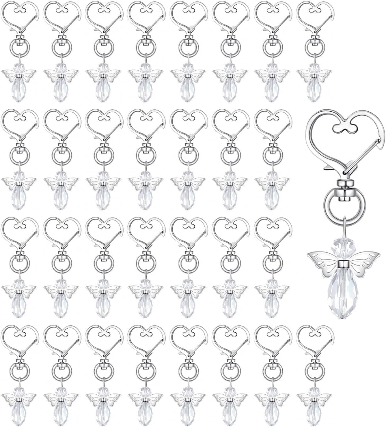 Cuadrícula con más de treinta llaveros iguales, cada uno con un mosquetón en forma de corazón y colgando un ángel de cristal transparente con alas facetadas, y uno de ellos ampliado a la derecha