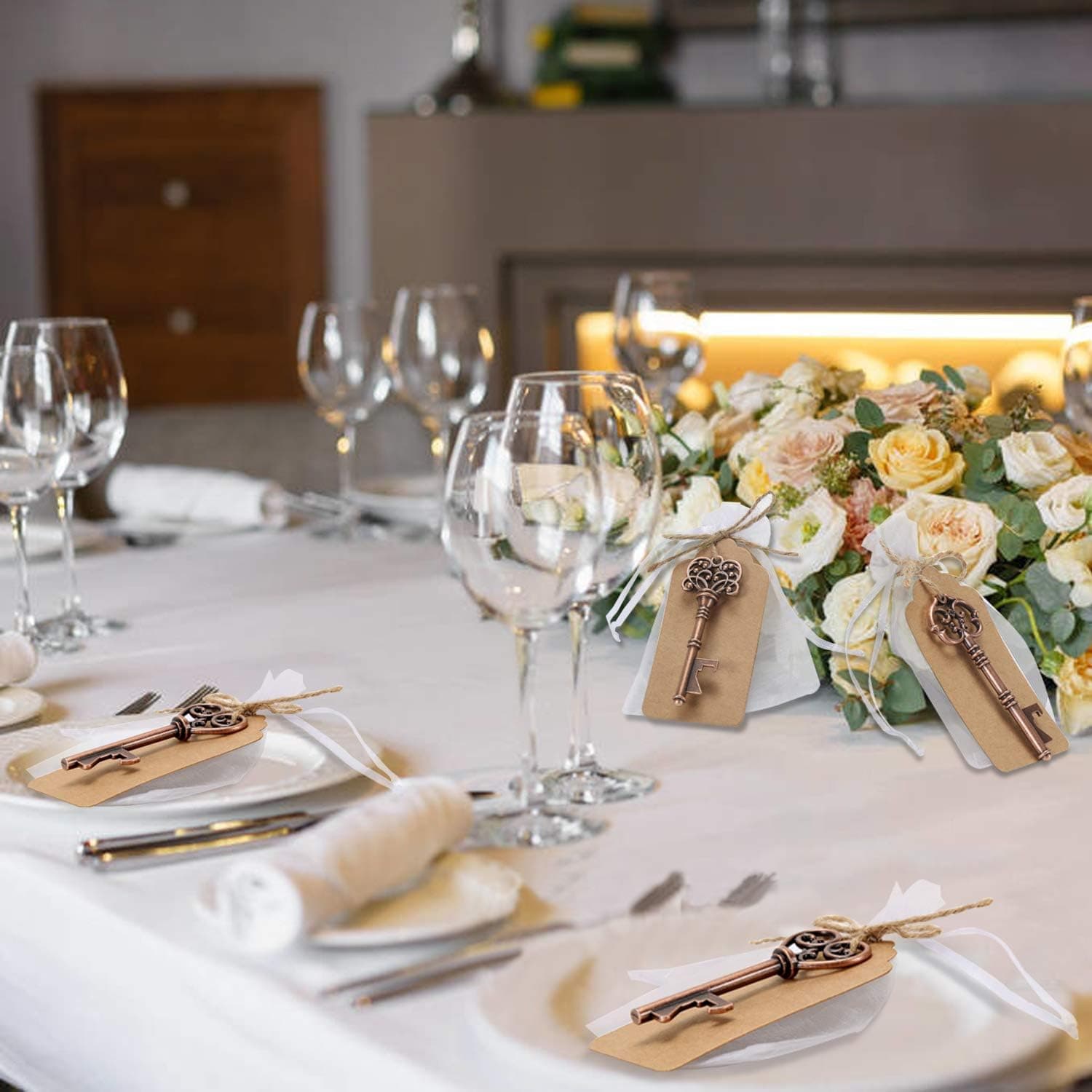Las llaves colocadas sobre los platos de una mesa puesta, junto a las copas y el centro de flores