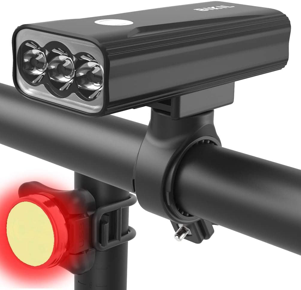 Luz delantera de bicicleta negra con tres LED montada en el manillar, junto a la luz trasera roja