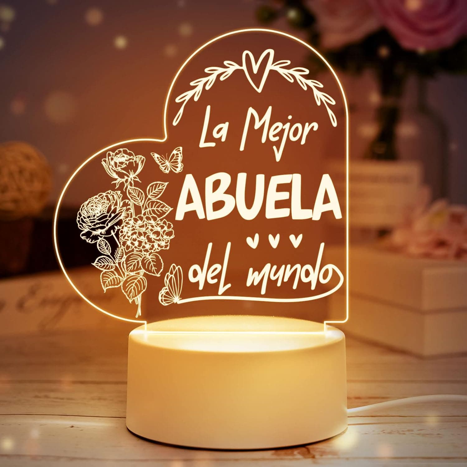 Lámpara nocturna con una placa acrílica grabada con flores y mariposas encendida en una habitación oscura
