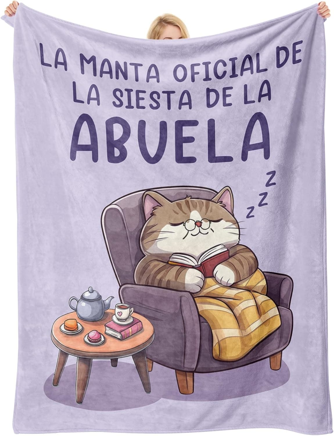 Manta estampada con un gatito durmiendo y el texto «la manta oficial de la siesta de la abuela»