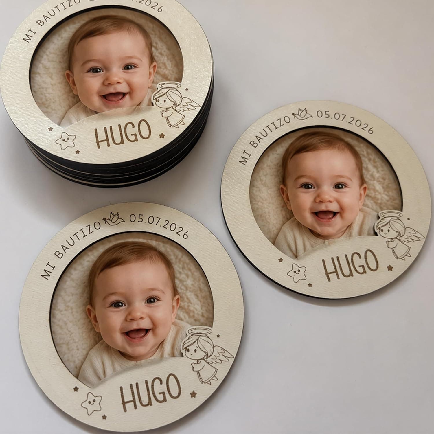 Tres imanes iguales con la foto de un bebé sonriendo, el nombre «Hugo» y la fecha, uno de ellos apilado sobre el resto del lote