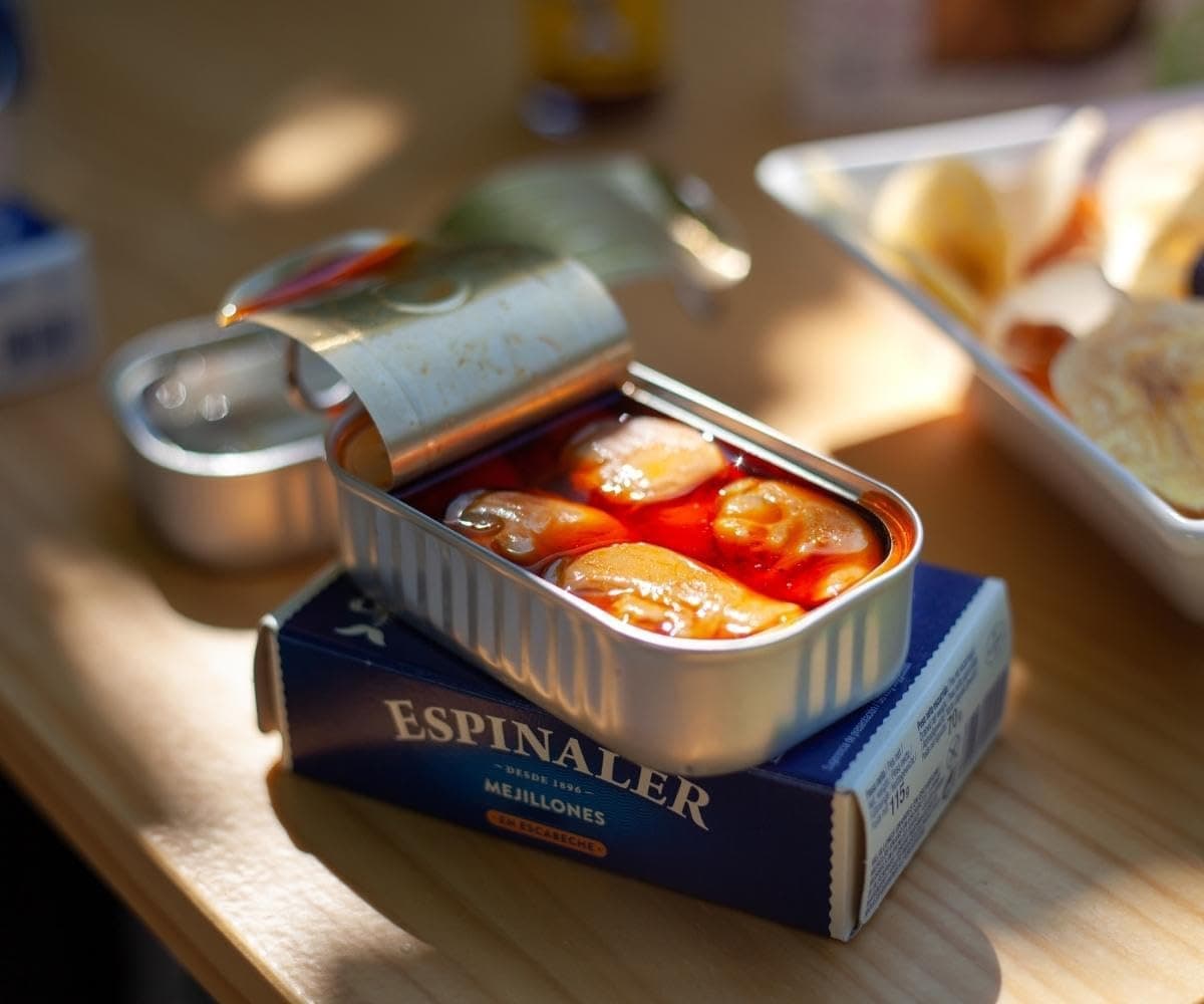 Lata de mejillones en escabeche Espinaler abierta sobre una mesa de madera