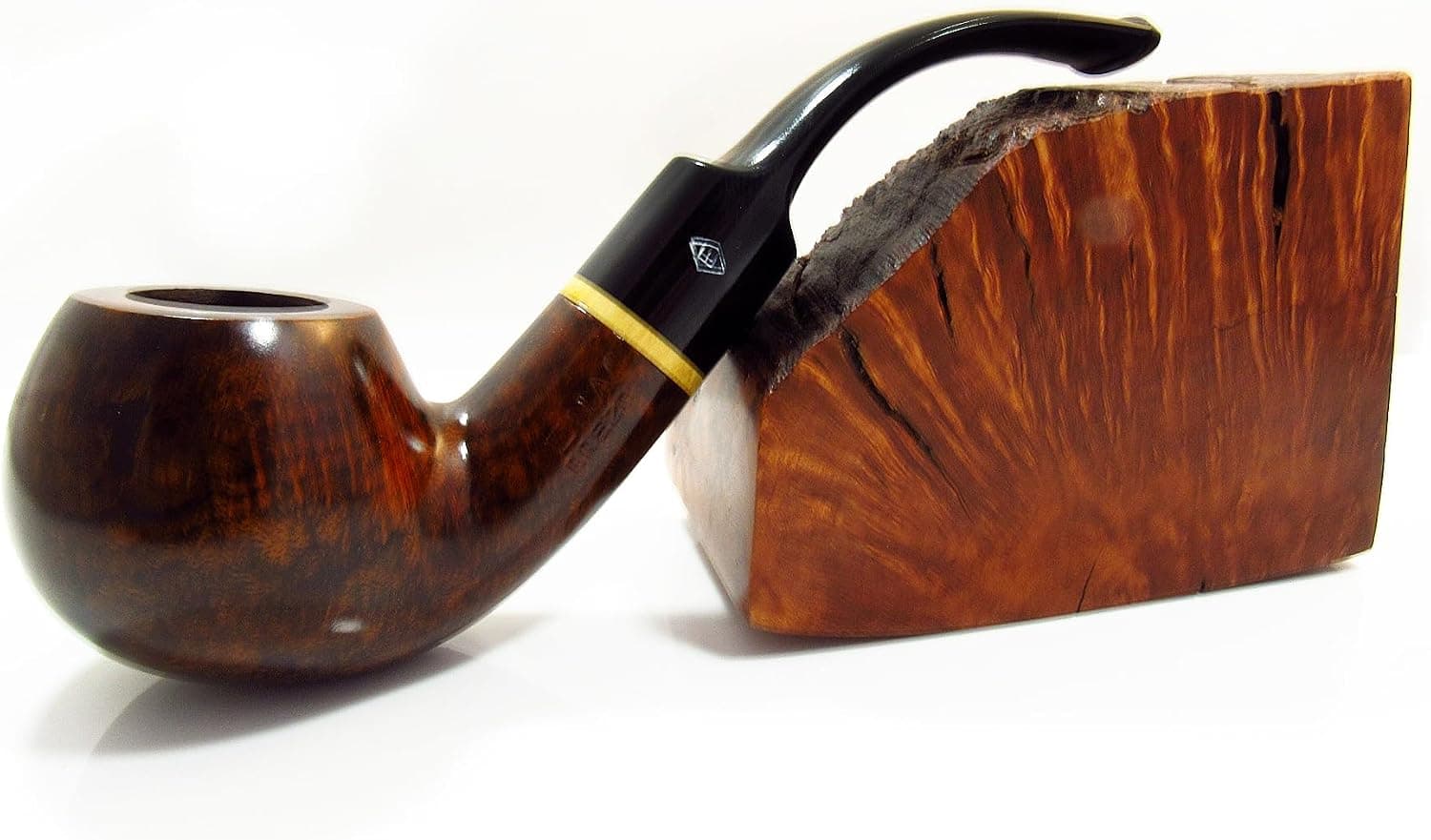 Pipa de madera de brezo con la cazoleta redondeada y la boquilla curva negra, apoyada sobre el bloque de madera veteada del que se talla