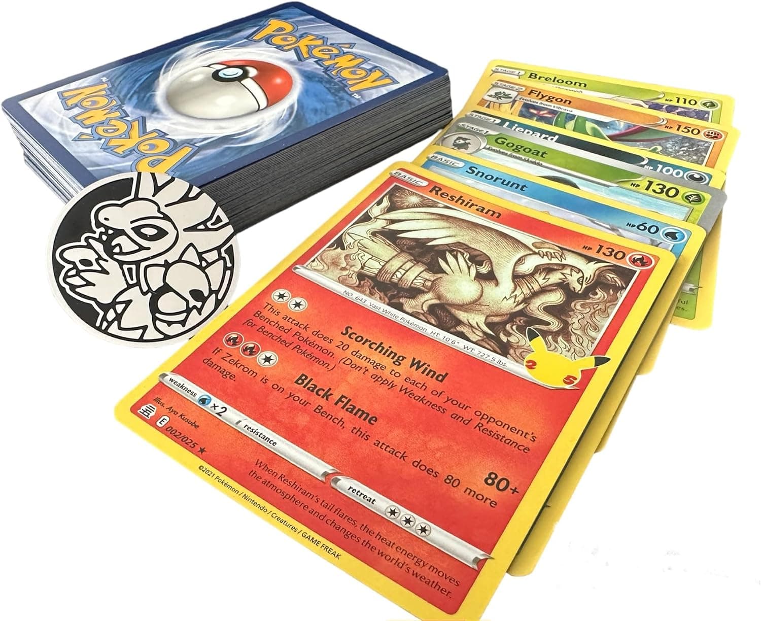 Las cincuenta cartas Pokémon abiertas en abanico junto a la moneda metálica oficial