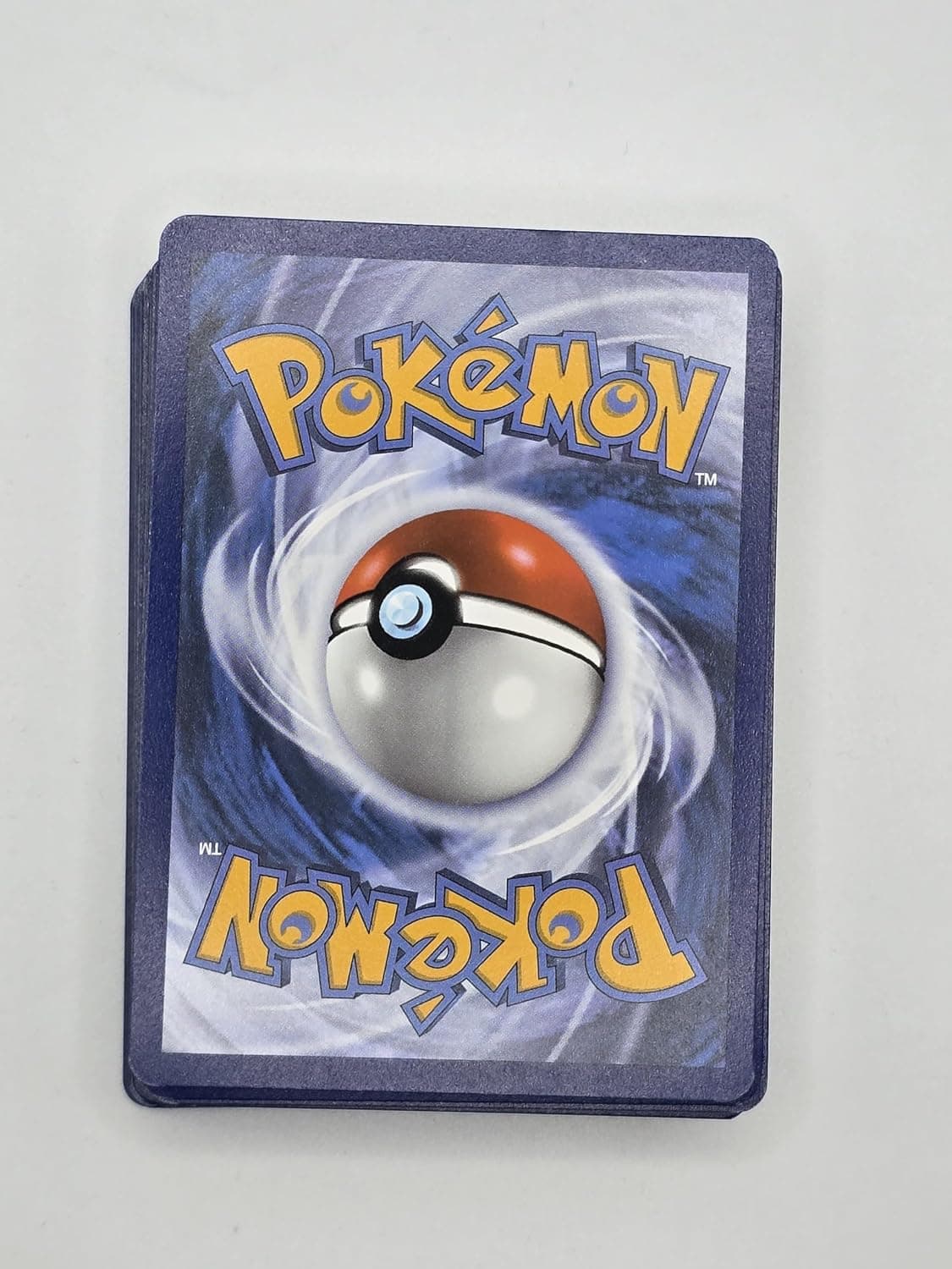 Sobre transparente con las cincuenta cartas Pokémon en abanico, mostrando el brillo de las láminas