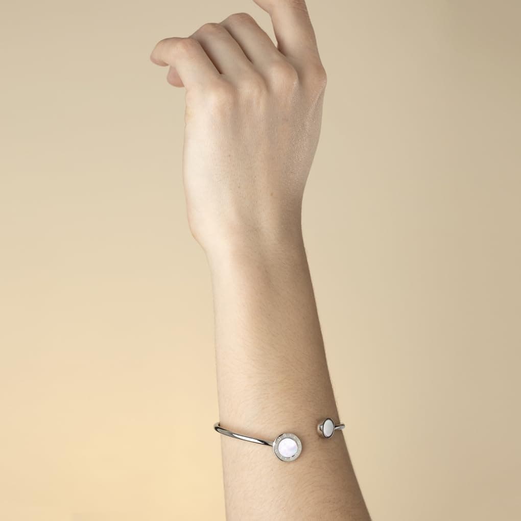 La pulsera puesta en una muñeca, con los círculos de nácar visibles sobre la piel