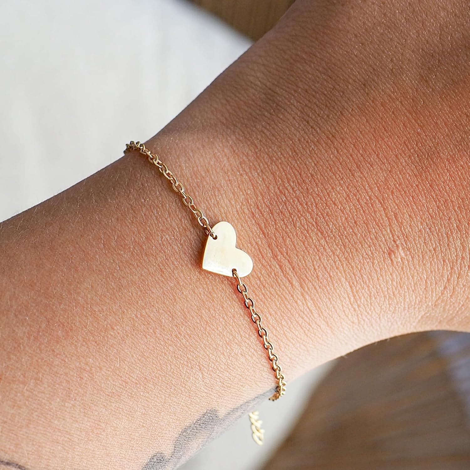 La pulsera puesta en una muñeca, con el corazón dorado apoyado en la parte de arriba