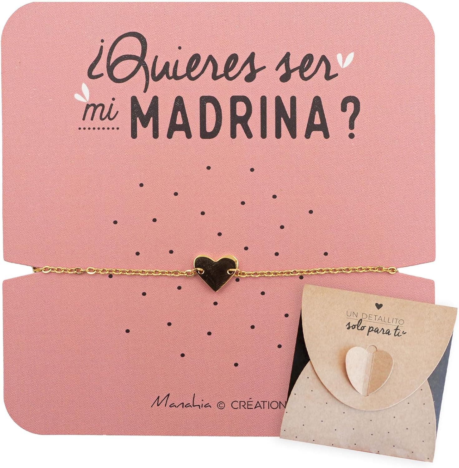 Pulsera de cadena dorada con un corazón liso en el centro, sujeta a una tarjeta rosa empolvado con «¿quieres ser mi madrina?» en letra manuscrita, junto al sobre kraft con un corazón de cierre que dice «un detallito solo para ti»
