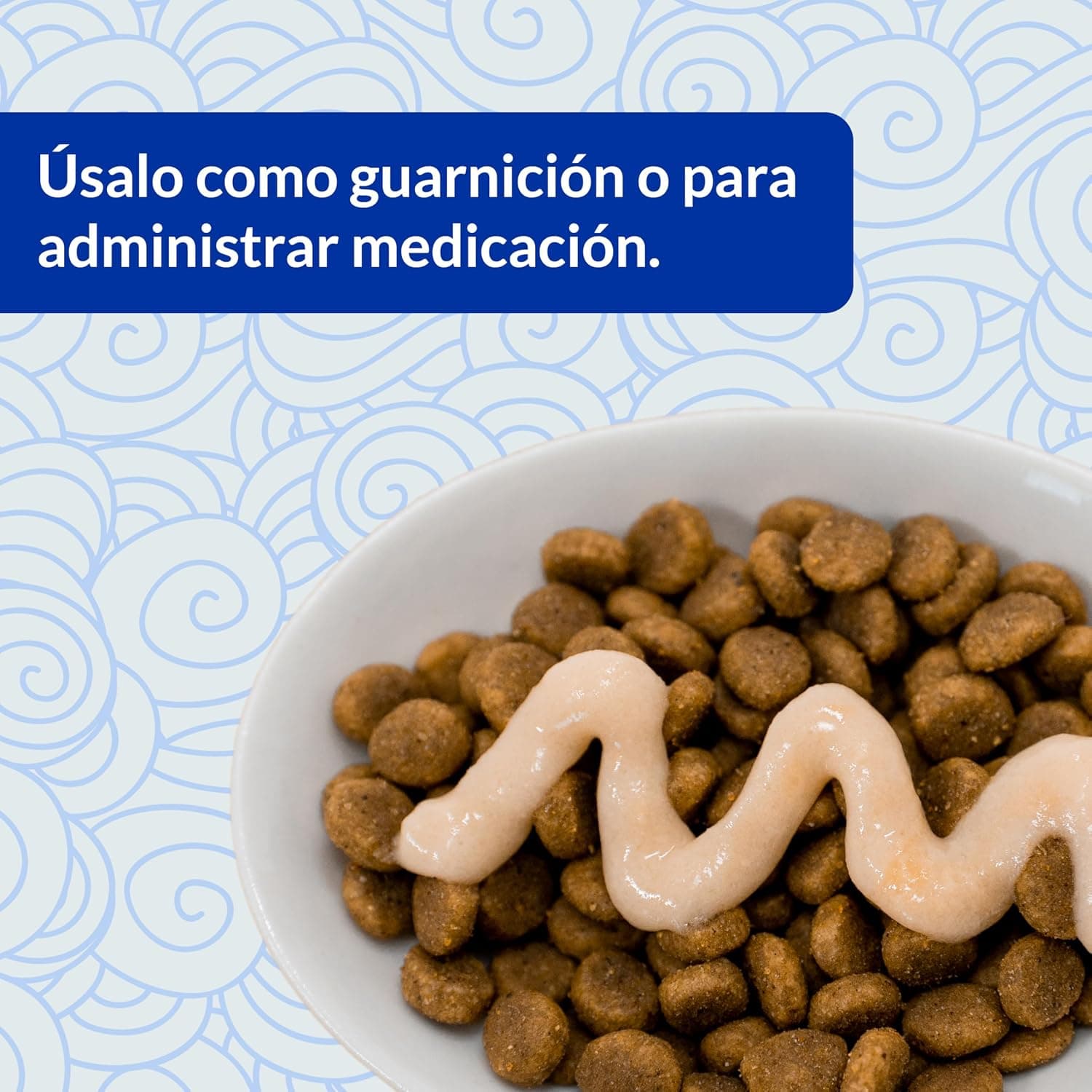 Un tubo de crema servido en espiral sobre un cuenco de pienso