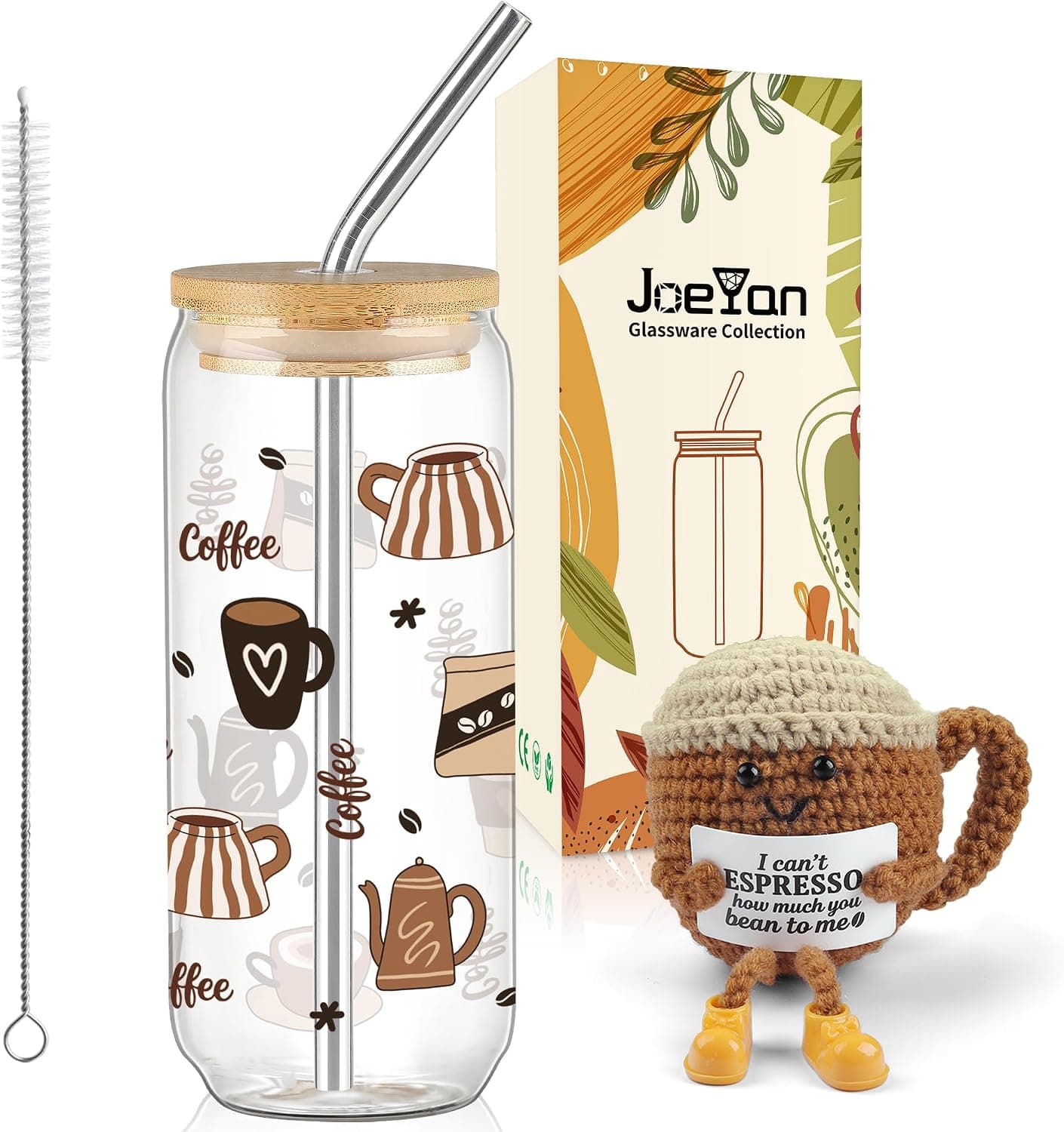 El vaso de cristal con la pajita de acero y el muñeco de ganchillo con forma de café enganchado al asa