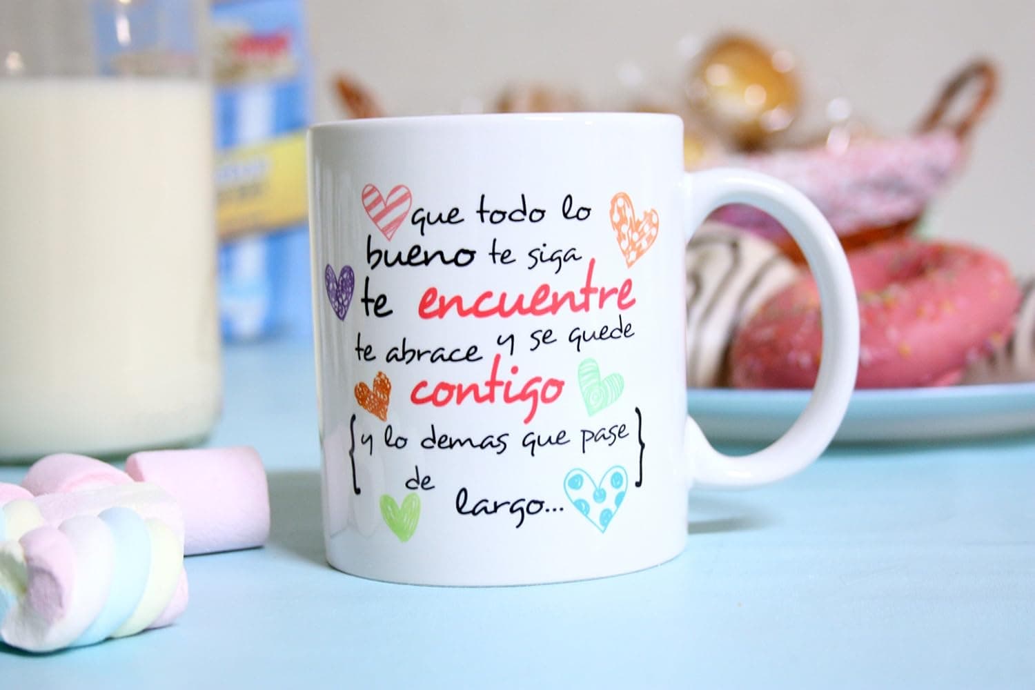 La taza sostenida con las dos manos, a la altura del pecho