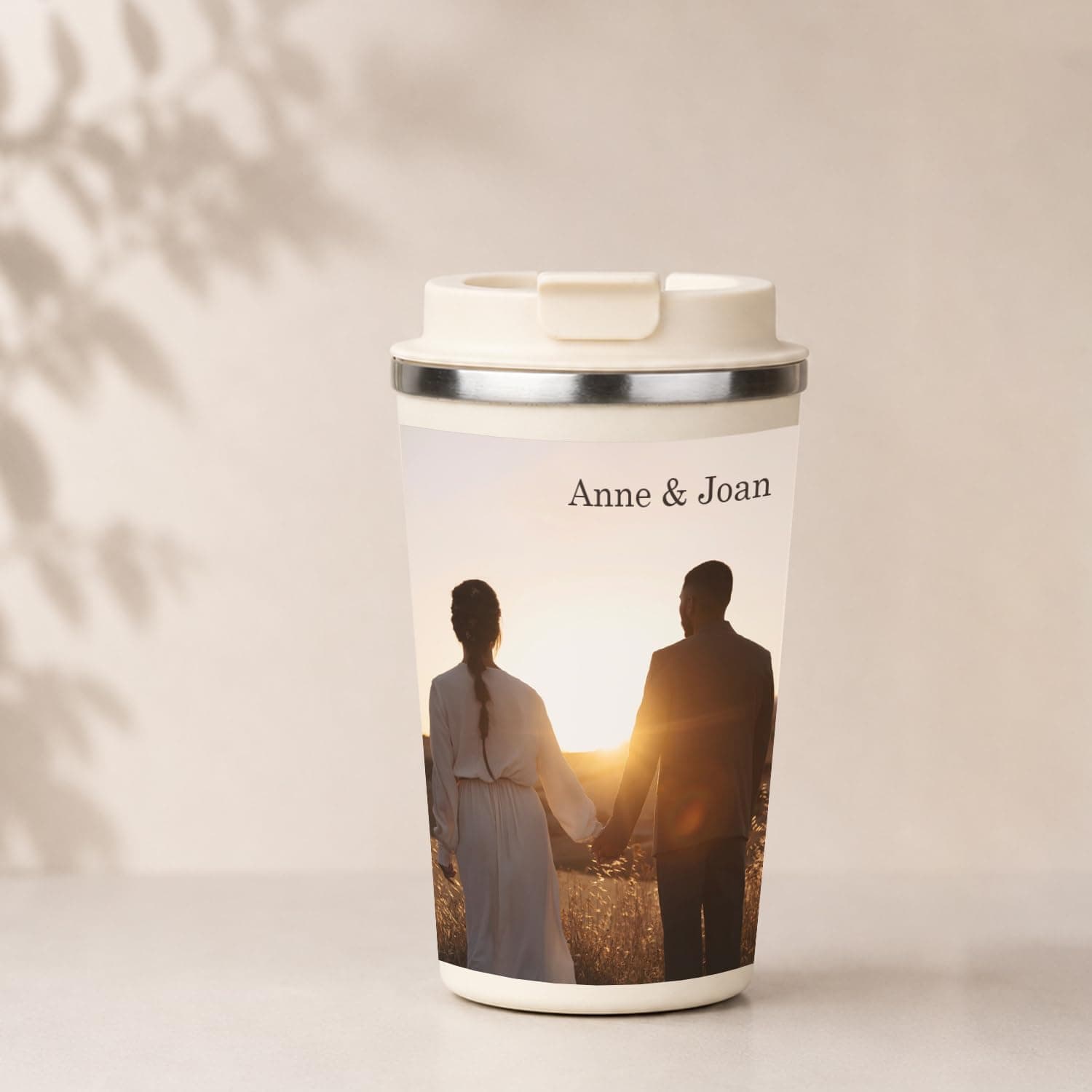 Vaso térmico de acero color beige con el nombre grabado, tapa hermética y asa lateral