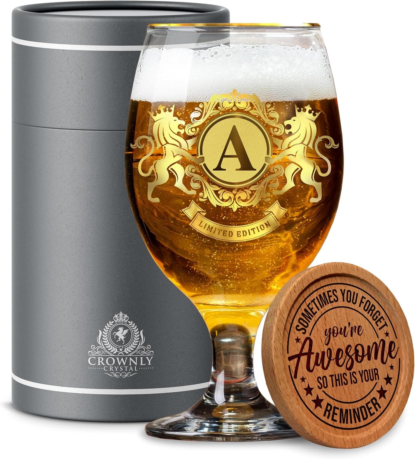 Copa de cerveza de cristal con escudo dorado, dos leones y la inicial "A" grabada, junto a su envase cilíndrico y un posavasos de madera | /img/regalos/vaso-cerveza-personalizado-crownly-2.jpg | Segunda imagen de la copa de cerveza personalizada Crownly Crystal