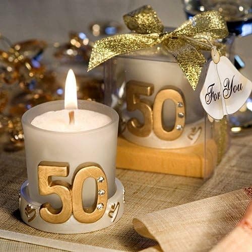 Vela individual con el número 50 dorado en relieve, junto a su caja de regalo con lazo