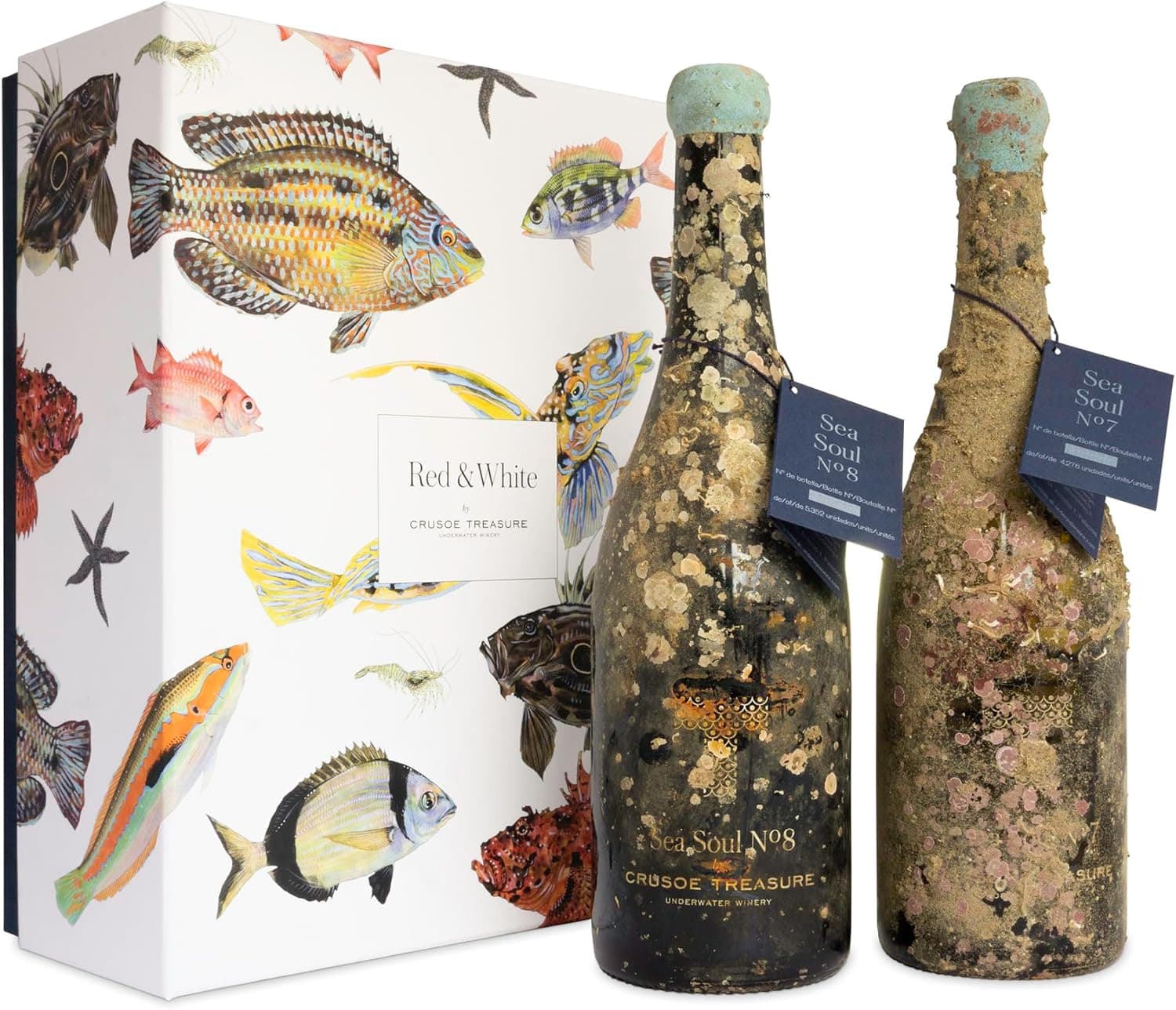 Las dos botellas de vino submarino Crusoe Treasure, tinto y blanco, con incrustaciones marinas distintas en cada una, junto a su estuche ilustrado con peces