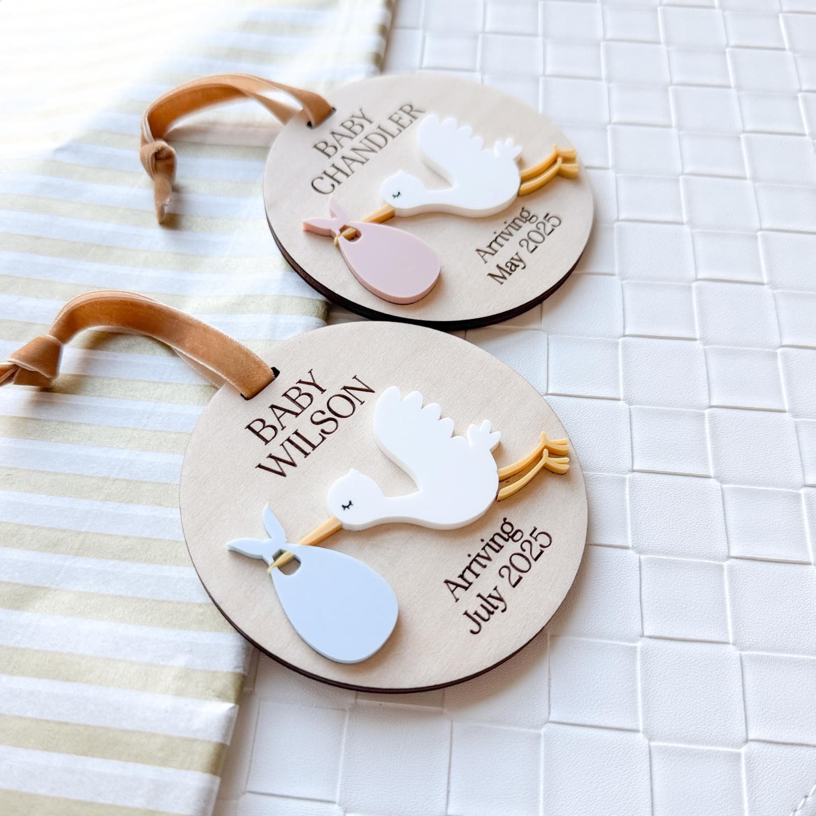 Layered wood and acrylic baby announcement ornament. Personalize with baby’s last name and arrival month and year. Features a white acrylic stork and customize with your choice of acrylic color for stork bag.