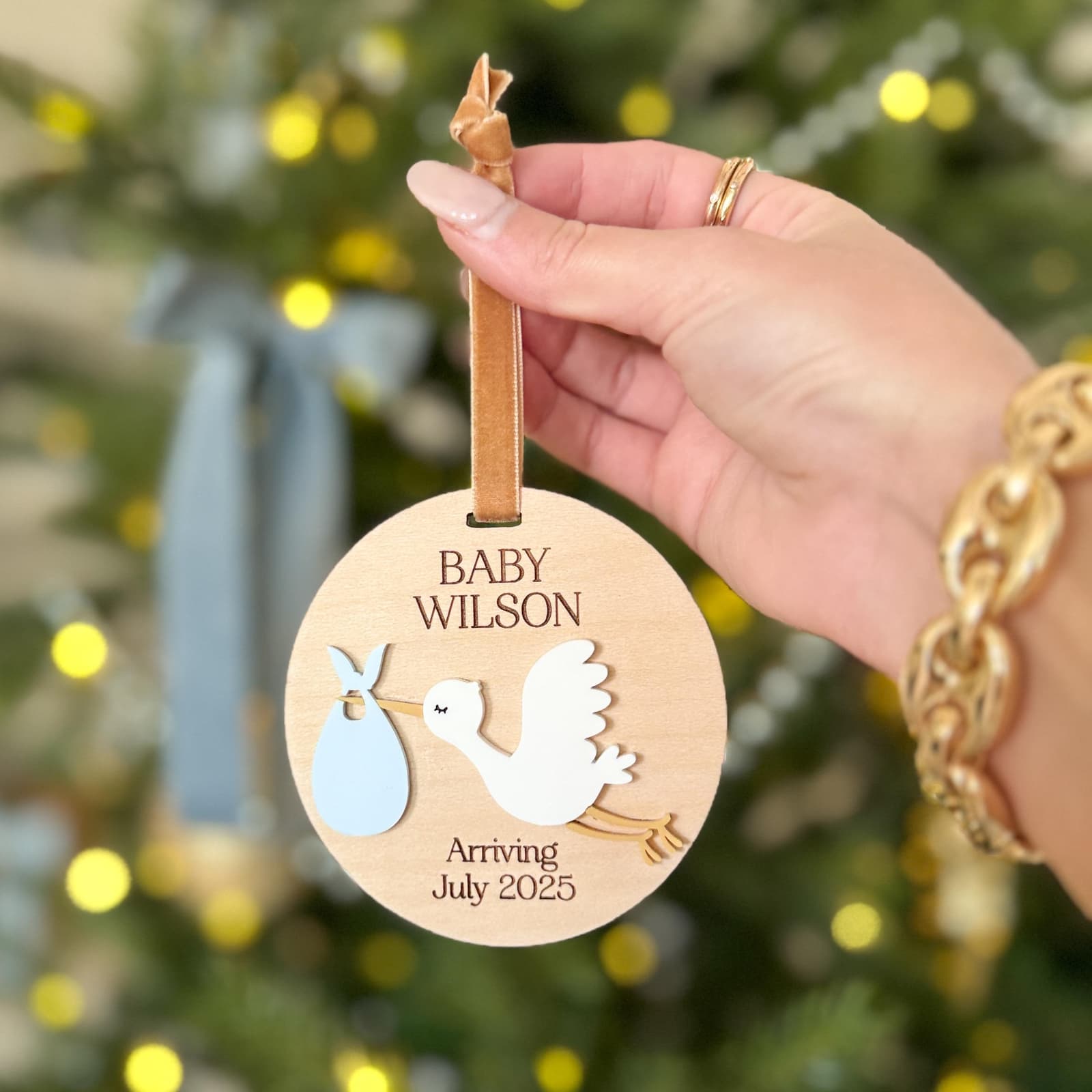 Layered wood and acrylic baby announcement ornament. Personalize with baby’s last name and arrival month and year. Features a white acrylic stork and customize with your choice of acrylic color for stork bag.
