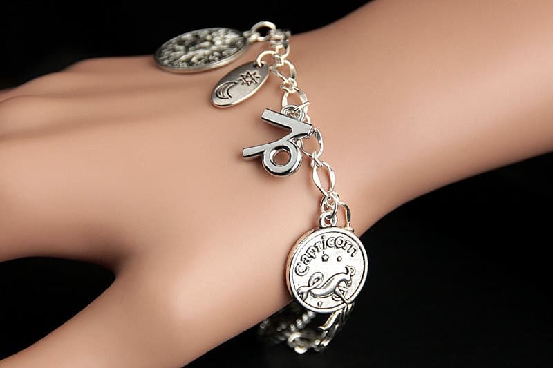 Pulsera de amuletos de Capricornio puesta en la muñeca mostrando el detalle de cada colgante