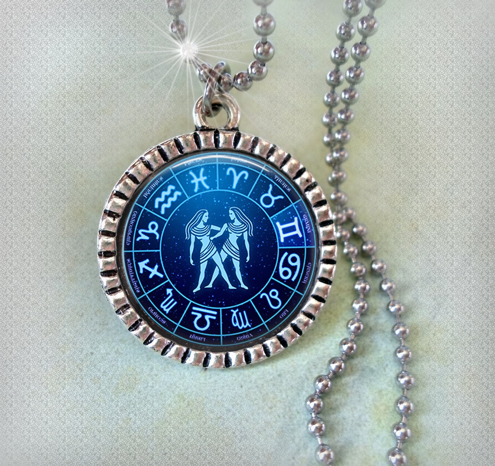 Colgante de Géminis con la rueda del zodiaco y el símbolo de Los Gemelos en azul