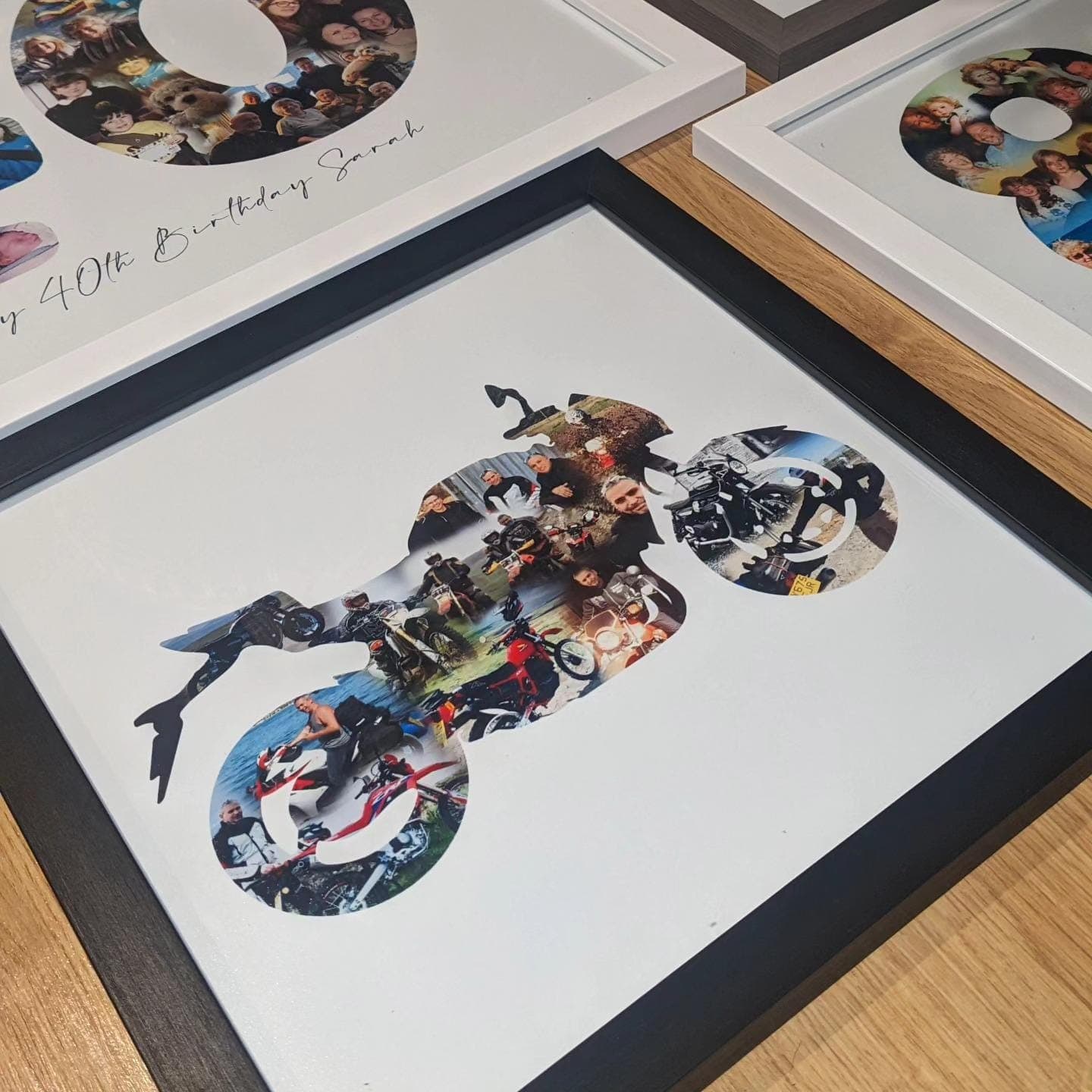 a couple of framed pictures sitting on top of a wooden table