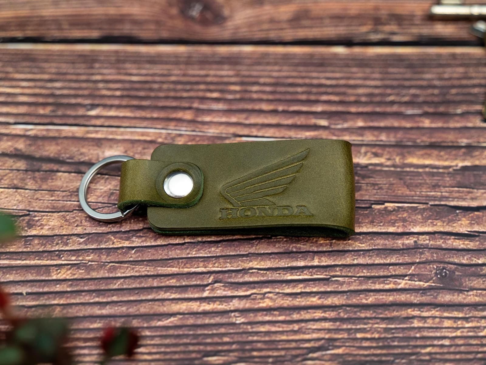 Folded olive green keyring/keychain embossed with the Honda motorbike logo. Stainless steel split ring and rivet.