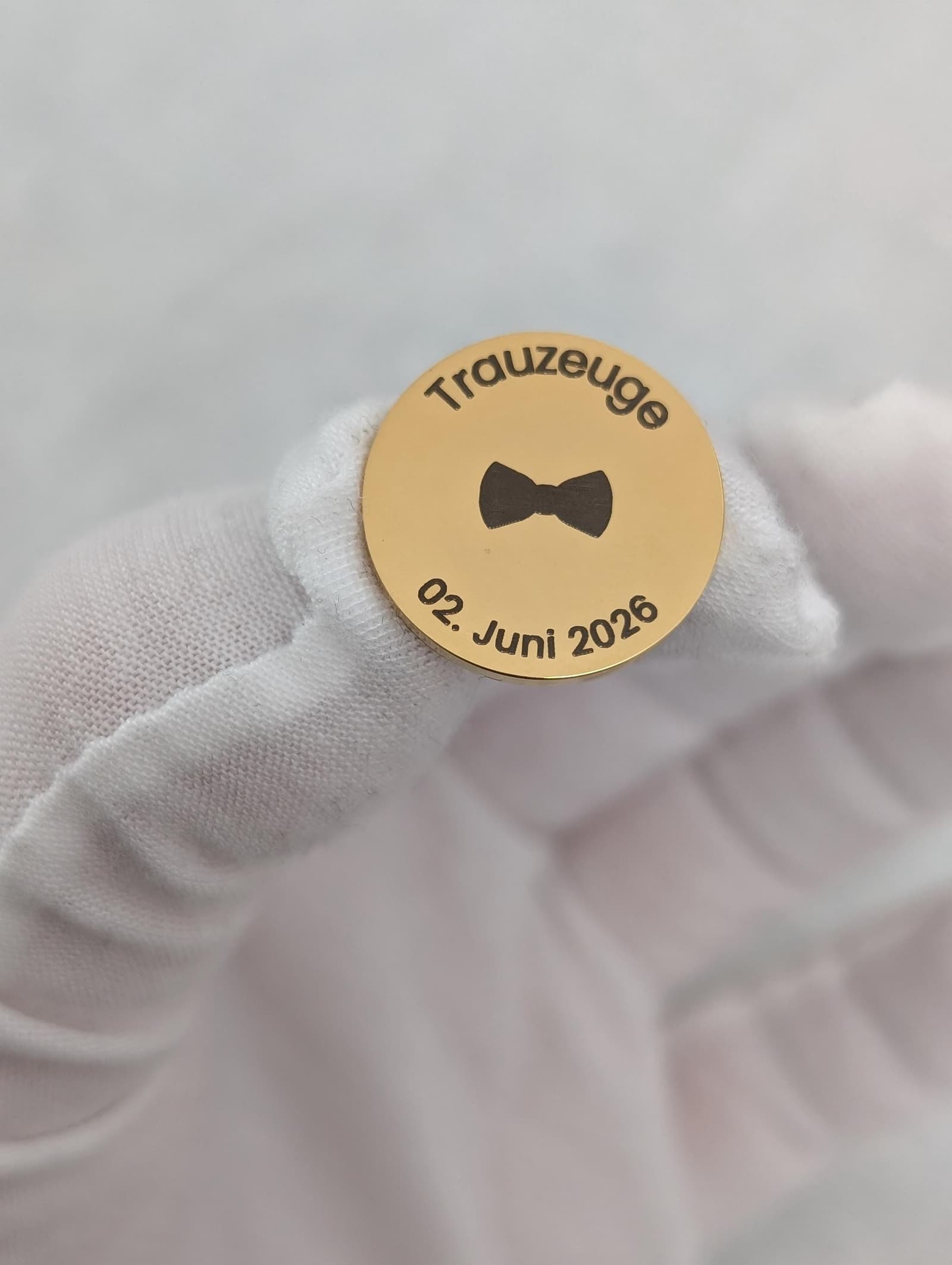Pin de boda personalizado sujeto en la mano