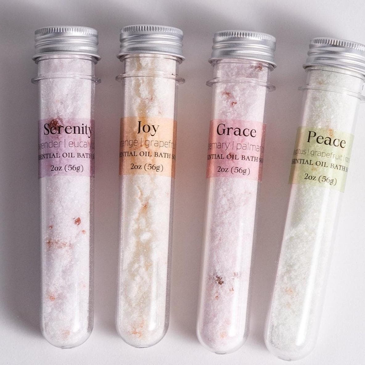 Handmade essential oil bath soak gift set from Megan’s Pantry includes four 2 oz tubes in signature scents: Serenity, Joy, Grace, and Peace. Made with natural salts and organic essential oils, beautifully packaged in a kraft gift box with pine shred and ribbon. Perfect spa-inspired gift for birthdays, showers, or relaxing self-care rituals.
