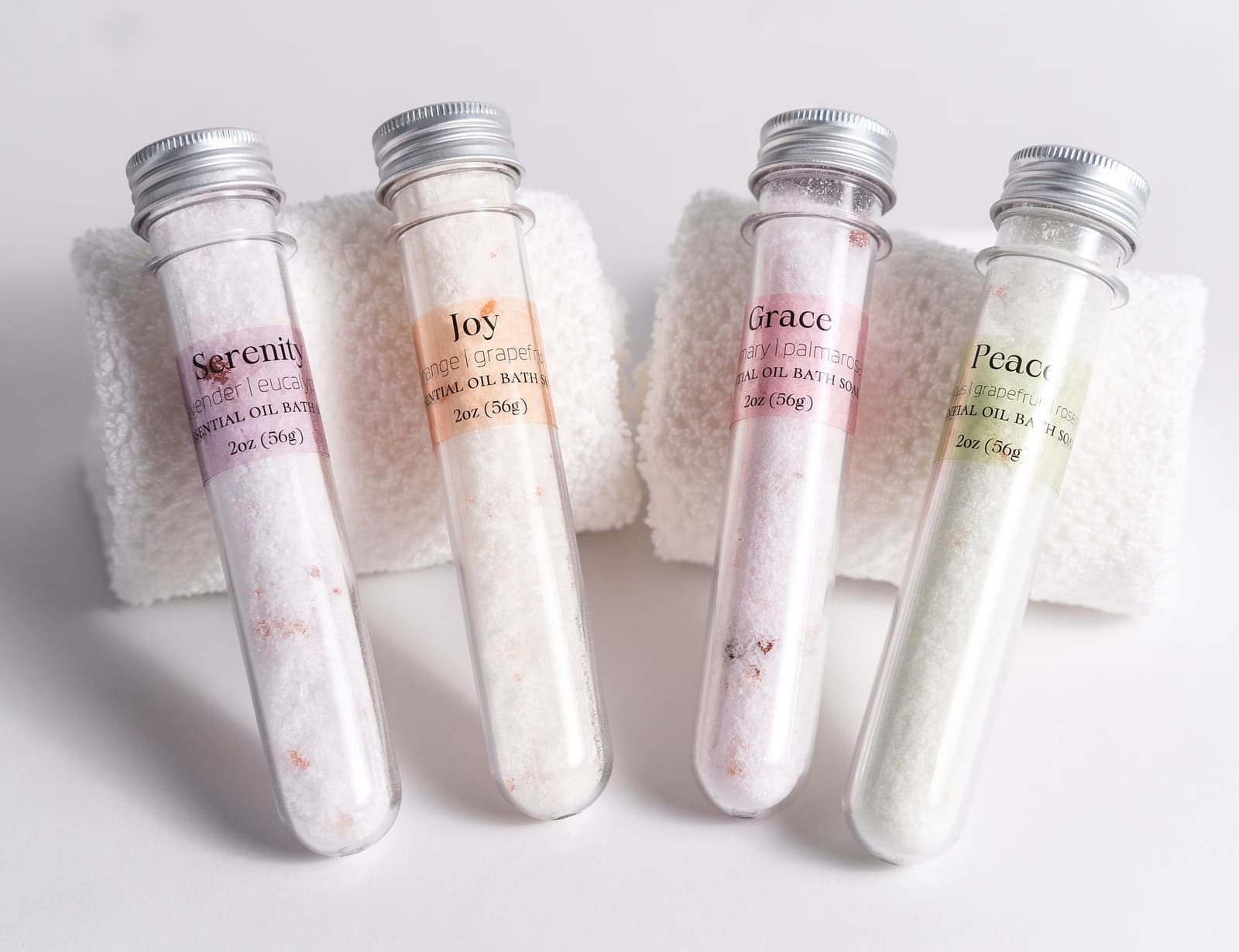 Handmade essential oil bath soak gift set from Megan’s Pantry includes four 2 oz tubes in signature scents: Serenity, Joy, Grace, and Peace. Made with natural salts and organic essential oils, beautifully packaged in a kraft gift box with pine shred and ribbon. Perfect spa-inspired gift for birthdays, showers, or relaxing self-care rituals.
