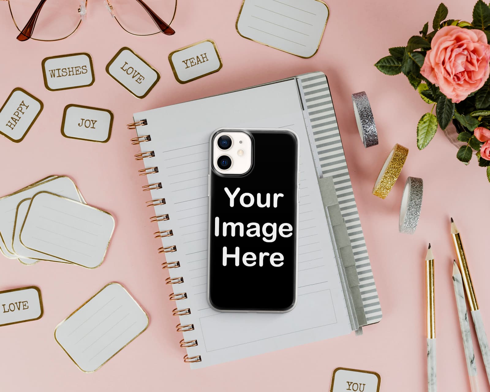 Funda de móvil rosa personalizada, sobre una libreta con flores alrededor