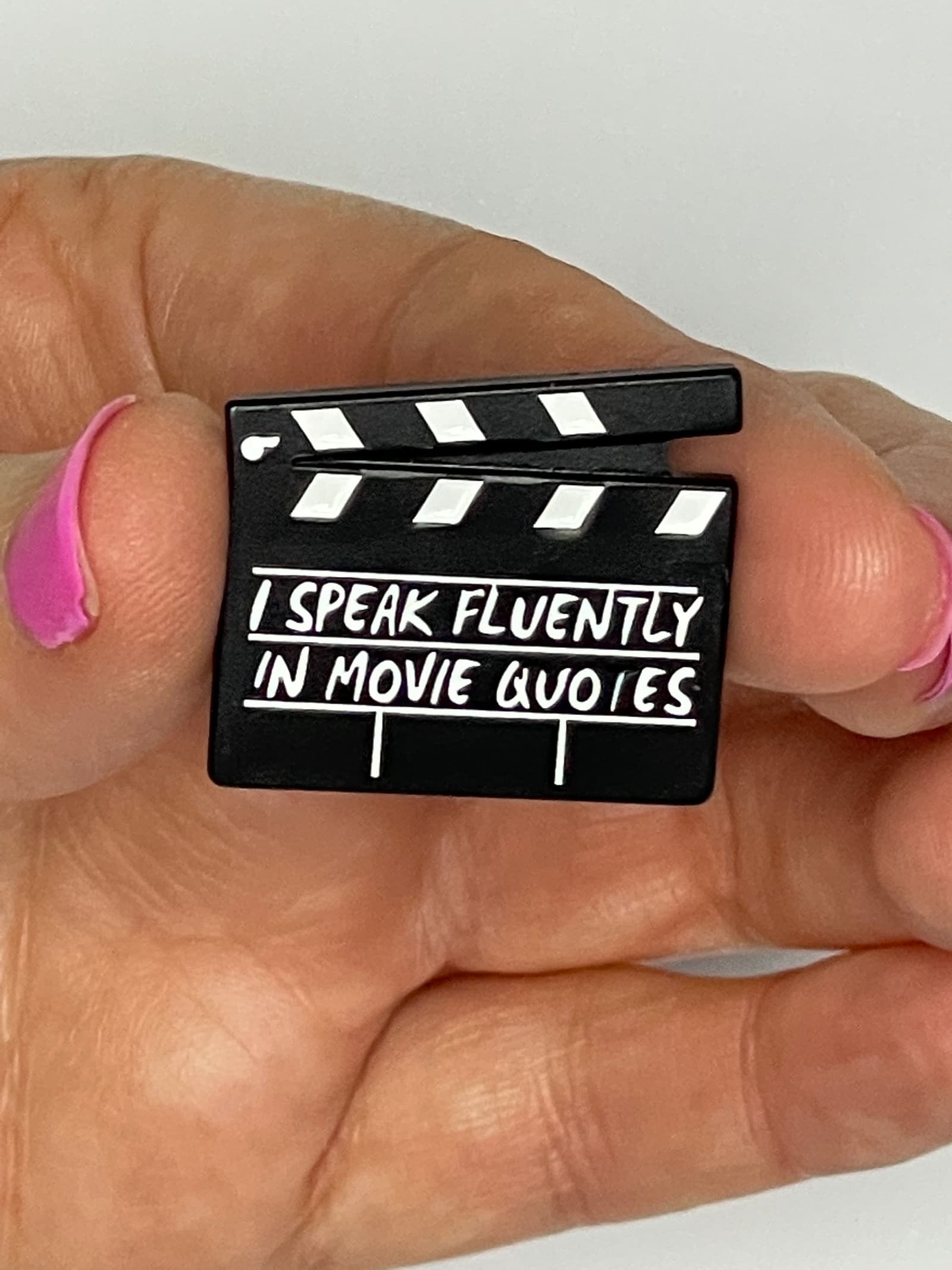 Pin de esmalte con claqueta de cine y frases de películas