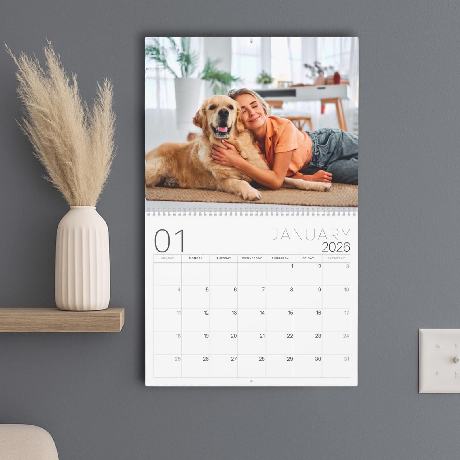 Calendario de pared colgado con la foto de una mujer abrazada a su perro sobre la hoja de enero