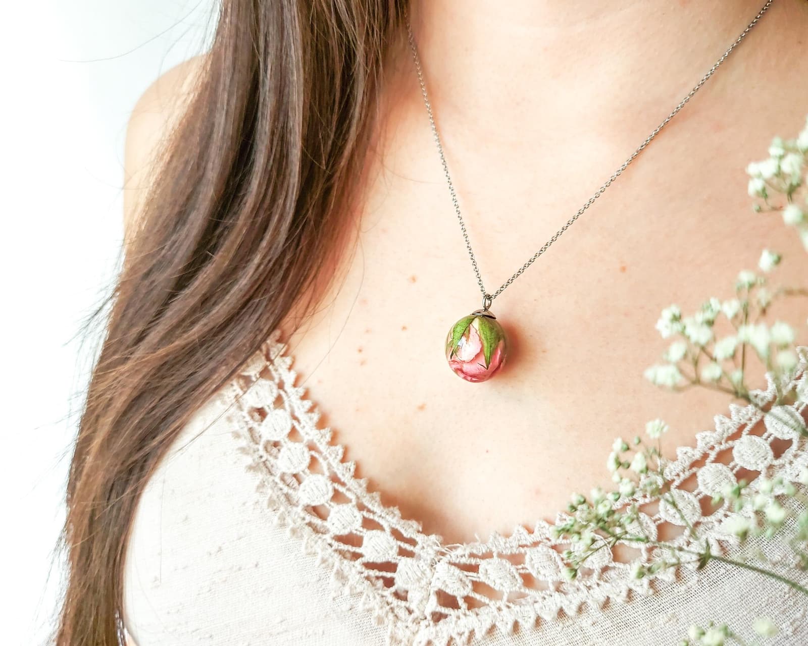 Model wearing a rose resin pendant necklace, showing the approximate size and how it rests on the chest.